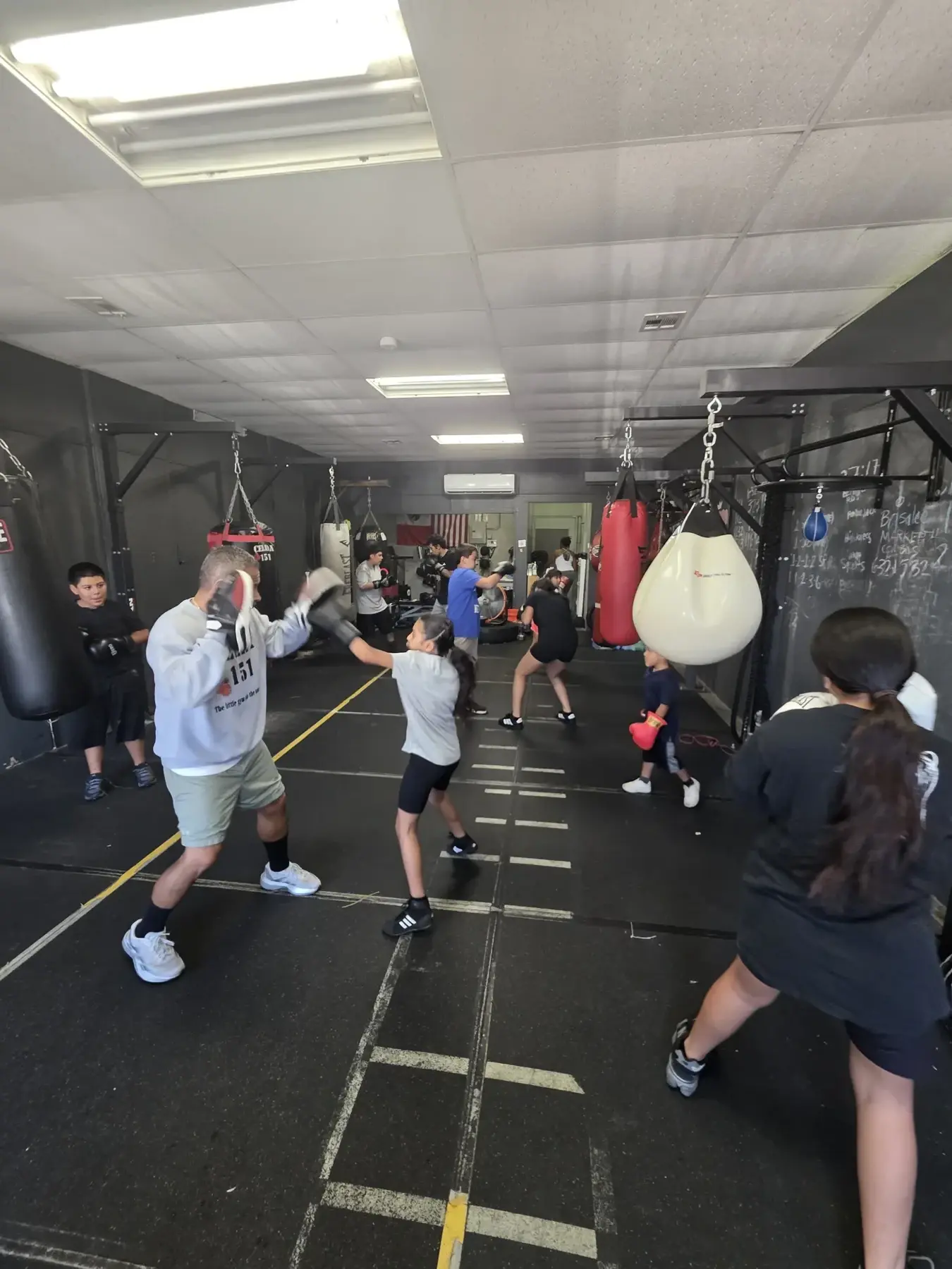 A Celda 151 boxing class trains together with coaches holding pads